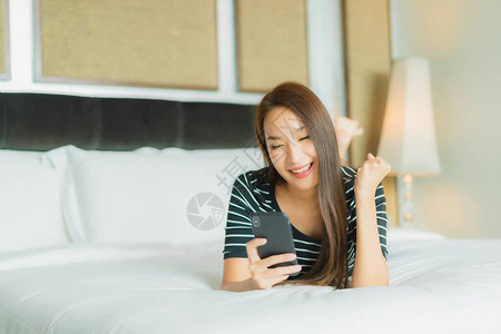 在卧室内用智能手机在床上使用睡衣图片