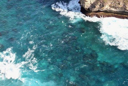 印度尼西亚巴厘岛努沙佩尼达岛岩石周围的明显深海蓝浪背景图片