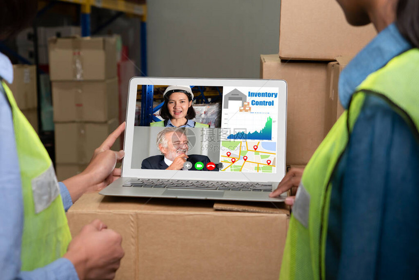 仓库工作人员在存储仓库的电脑屏幕上进行视频通话在线软件技术通过互联网络上的虚拟电话会议将在物流工厂作的图片