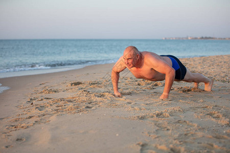 一位老人正在海边上推海上运动的中年男子度假的图片