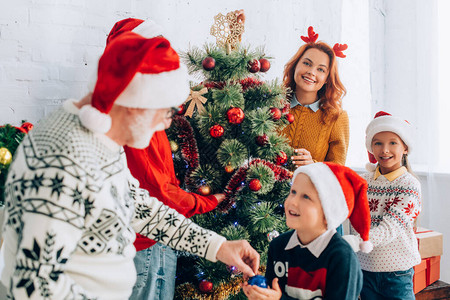 将圣诞树与家人一起装饰图片