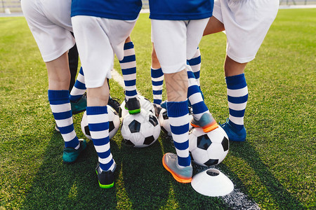 儿童足球队员校队的运动男孩子们挤成一队参加锦标赛玩家围成一圈穿着足球图片