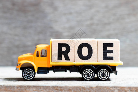 卡车在木材背景上持有用ROE字写成的字母块公平回图片