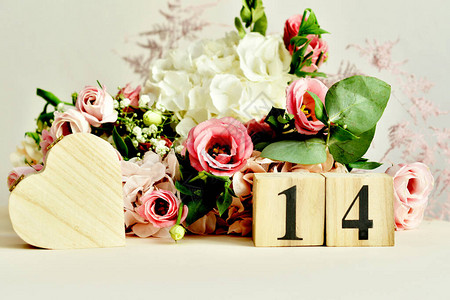 月14日在木块日历和精致的玫瑰洋桔梗绣球花束概念情人节2日图片