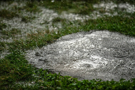 喷洒雾的雨滴落在水坑图片