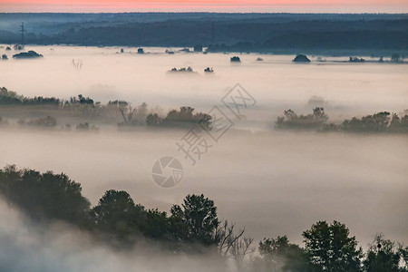 清晨秋天有浓雾笼罩着河谷的美丽的全景图片