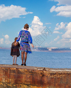 在蓝天白云的背景下一个带着孩子的女人图片