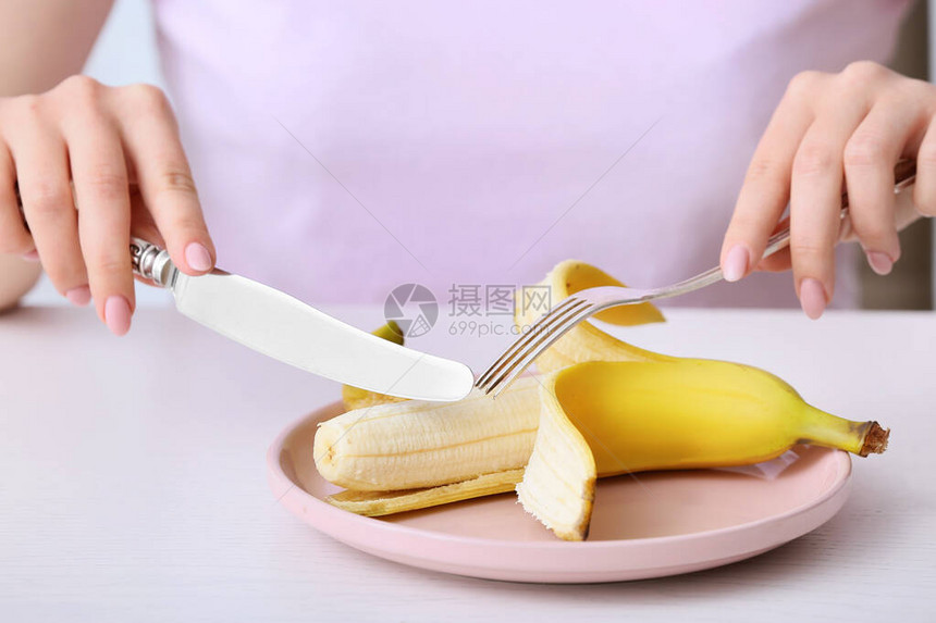 女人在桌边吃香蕉图片