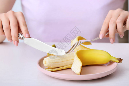 女人在桌边吃香蕉图片
