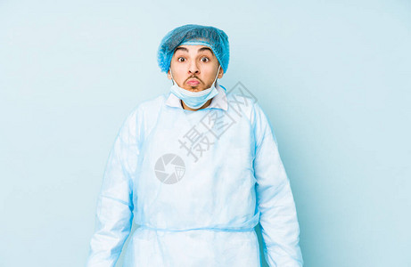 年轻的阿拉伯外科医生被孤立在蓝背景的肩膀上图片