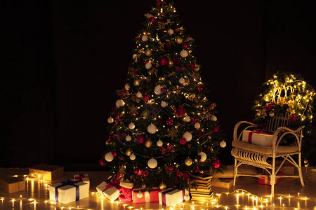 以圣诞树松为在夜房内部以花环灯图片