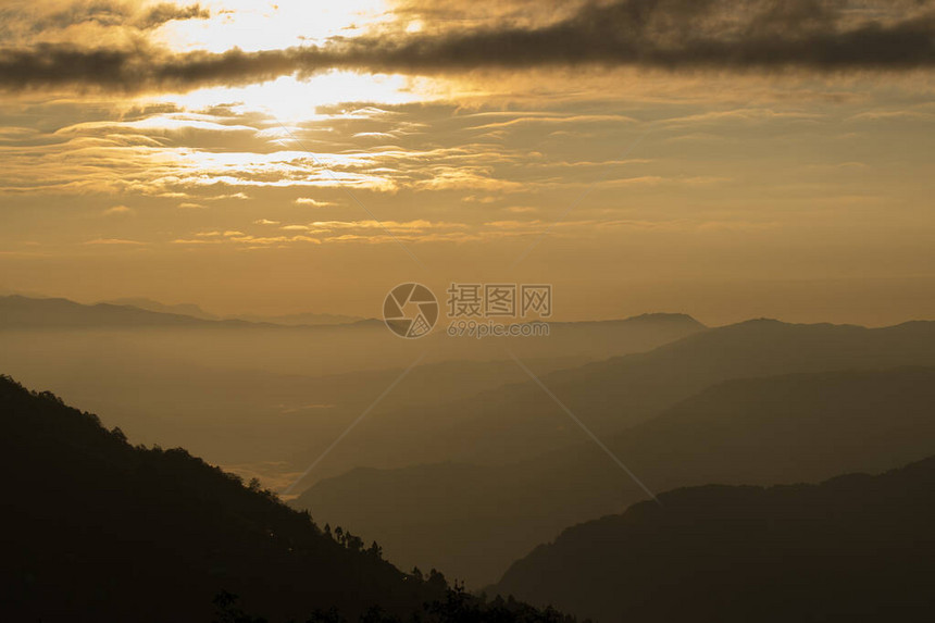 从印度锡金的Okhrey所看到的日出场景太阳从山后以橙色发光而升起照片图片