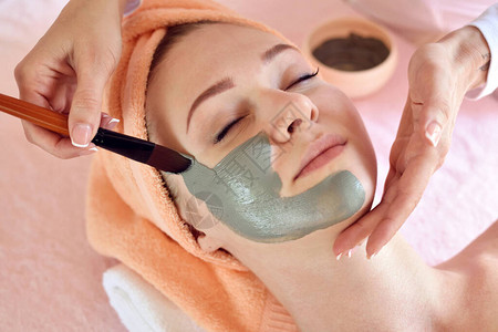 面部脱皮面膜水疗美容护肤女人在水疗沙龙接受美容师的面部护理图片