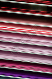 彩色纸堆在粉红色红色和紫色图片