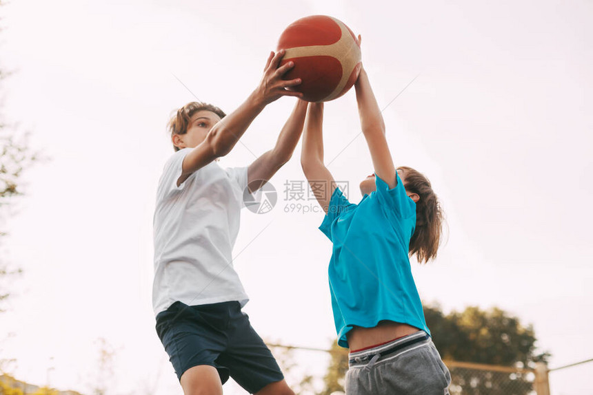 两个十几岁的男孩在操场上打篮球运动员在比赛中为球而战健康的生活方式图片