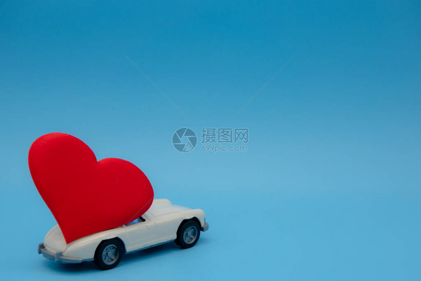 白色复古玩具车在粉红色的背景上运送一束鲜花明信片2月14日图片