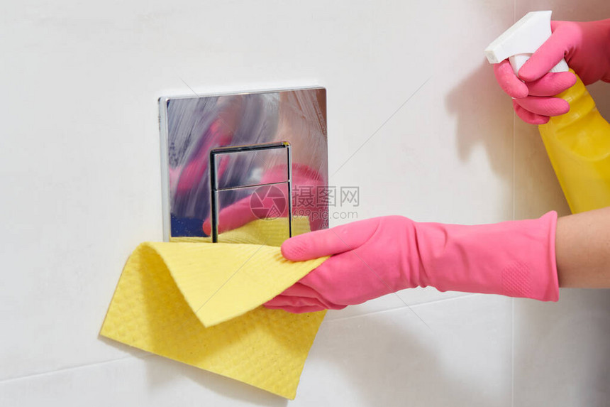 戴手套清洁手套和在砖墙上擦亮铬厕图片