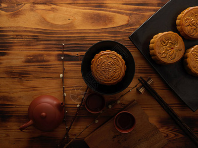 中秋节餐桌布置与传统月饼和茶壶的顶部视图月饼上的汉字用英文代表图片