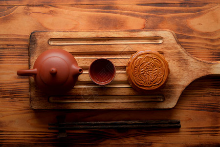 木板上传统月饼和茶具的顶视图月饼上的汉字用英文代表图片