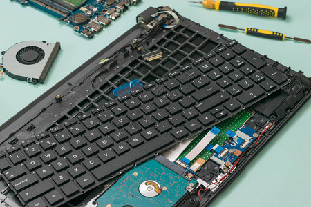 蓝色背景上的拆卸笔记本电脑和工具包修复和恢复笔记图片