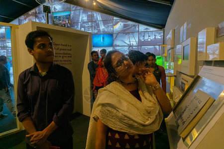 孟加拉女在博览会的多彩书展中阅读材料背景图片