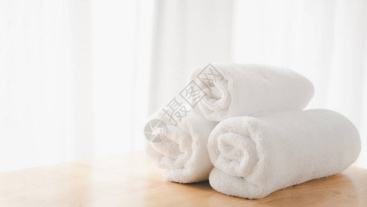 清洁白毛巾折叠在白色浴室背景图片