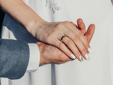 结婚戒指的年轻人的手婚礼当天的详细信息马蹄莲花配偶新婚夫图片
