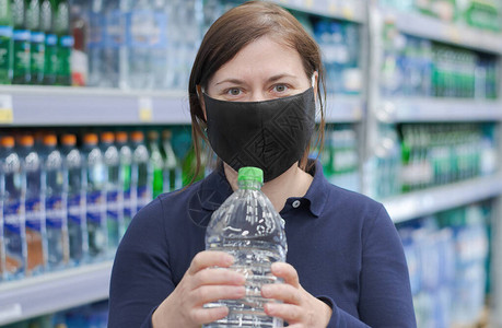 戴着防护医用口罩的女士站在商店里背景图片