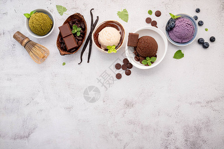 各种冰淇淋口味以碗蓝莓绿茶椰子和巧克力为背图片