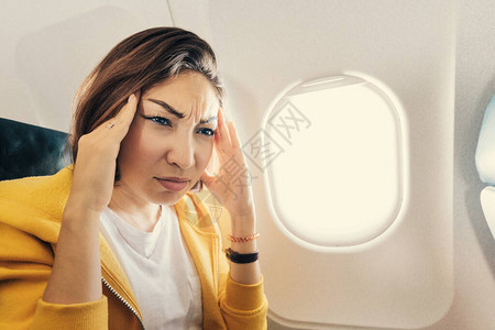 令人窒息的亚洲女人在飞机上飞行图片