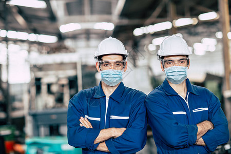 肖像工人在工厂作服务团队期间戴面罩或一次面罩图片