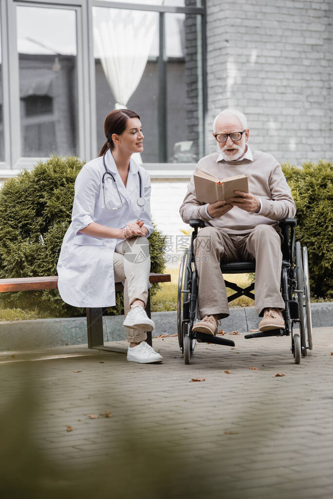 残疾老人坐在轮椅上看书图片