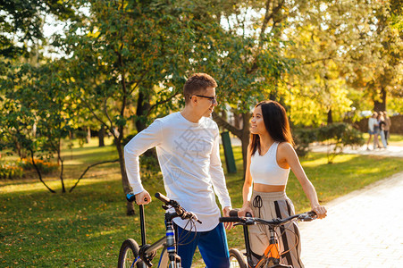 运动的年轻人站在公园的赛道上骑自行车图片