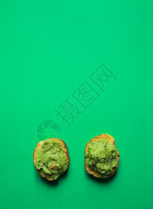 Crostini或带鳄梨酱的bruschetta小三明治在绿色图片