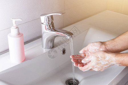 男人在白色脸盆附近洗手图片