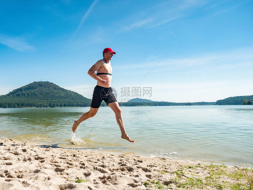 赛跑者在海滩的水中奔跑图片