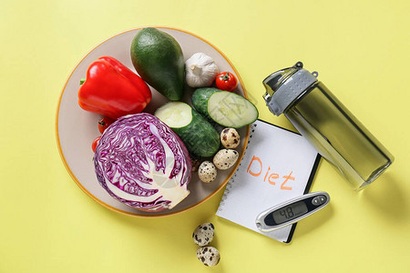 蔬菜含有DIET字词的笔记本水瓶和彩色底背景图片