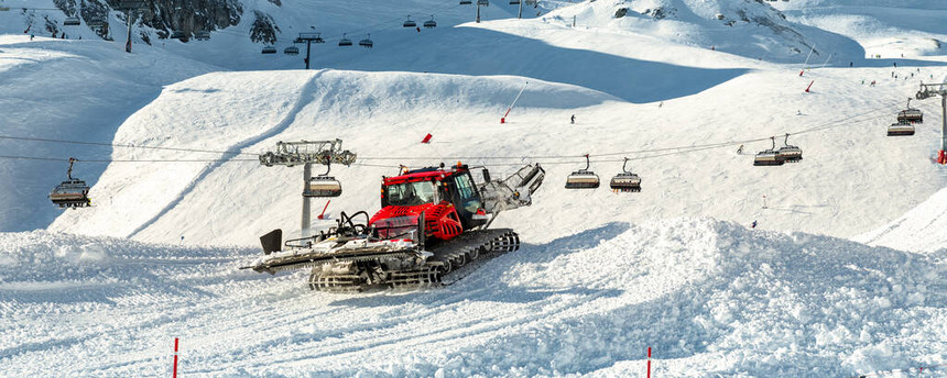 红色现代雪地车与雪犁机准备滑雪坡滑雪道hillalpine滑雪冬季度假胜地伊施格尔在奥地利重型机械山地设备图片