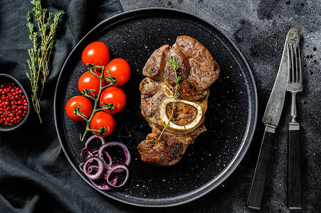 用番茄酱在骨OssoBuco上煮熟的肉OssoBuco炖肉黑色图片