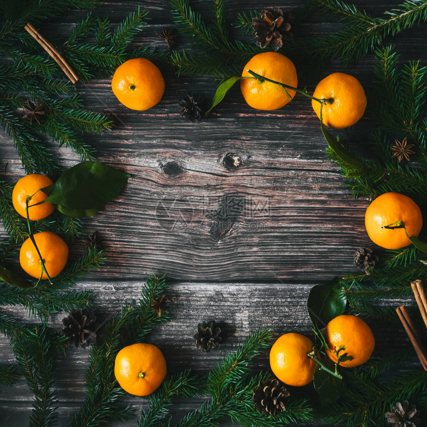 在圣诞节日木制背景上装饰的橘子纤维树枝锥形和卡达莫木棍查看图片