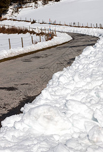 雪犁在两侧积雪的山路图片