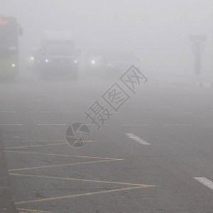 在清晨雾中横行穿越街口的男子可见度图片