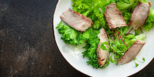 餐桌上的小牛肉切片仍维持着美味的鱼肉或白菜食物背景生动版面图片