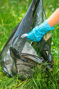 儿童从公园垃圾袋中扔垃圾的草地上收集图片