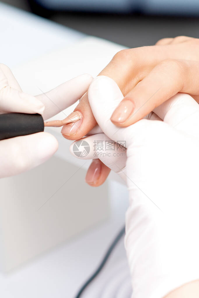 在美容院对女指甲施用蜜油指甲油的防图片