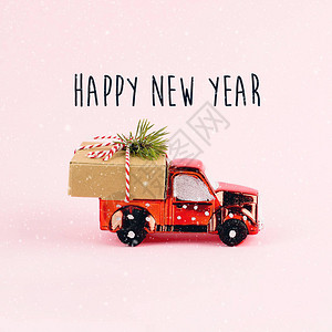送圣诞或新年礼物的红玩具车请在粉红图片
