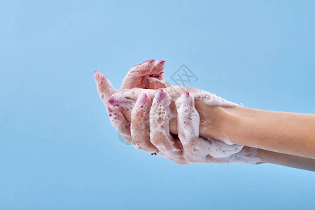 特写女人洗手蓝色背景上的清洁手图片