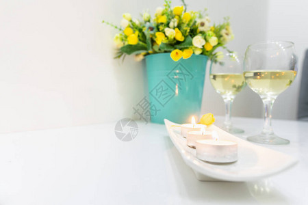 浪漫的蜡烛两个白葡萄酒杯和盛开的鲜花图片