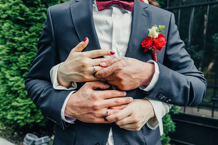 白金结婚戒指与钻石精致的玫瑰和绿色的新娘花束图片