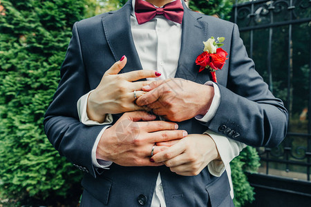 白金结婚戒指与钻石精致的玫瑰和绿色的新娘花束图片